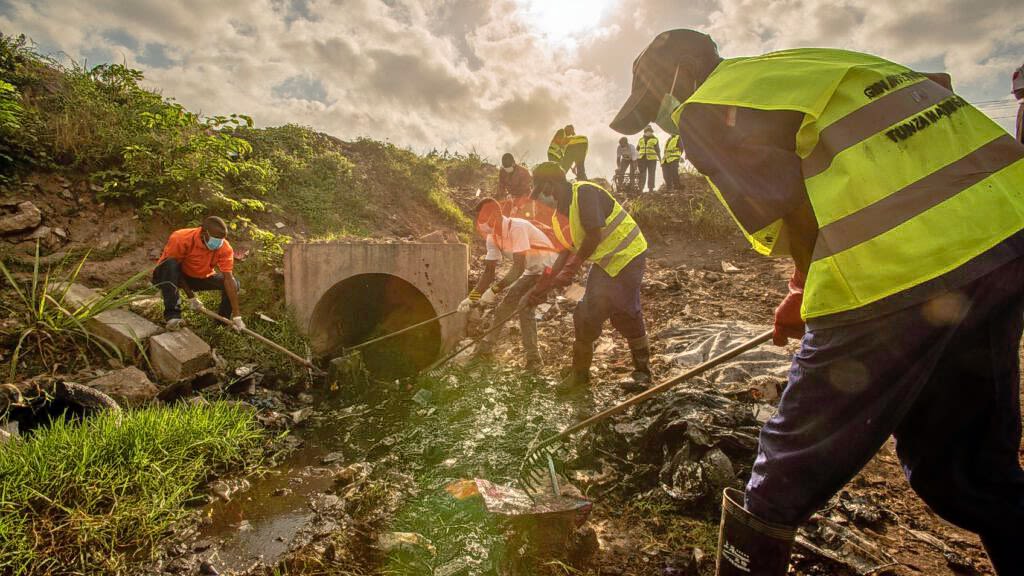 Youth volunteer take part in trash collection activities in a neighborhood with informal settlements.